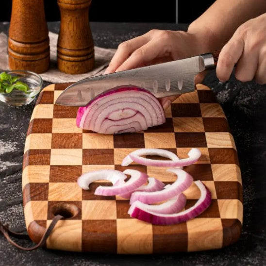 femme tranche oignon avec planche à découper damier