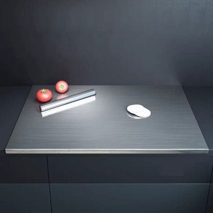 planche à découper inox sur plan de travail foncé